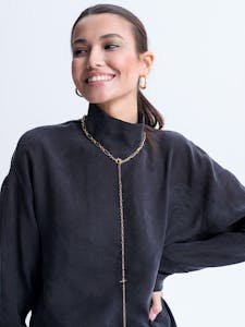 Smiling woman in a fashionable chain necklace and elegant black sweater